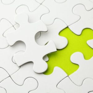 A photo of puzzle pieces with one laying out of its place, symbolizing integrating insurance into financial planning